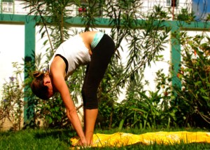 Exhale as you float down to the floor. Bend your knees in order to place your hands on either side of your feet.